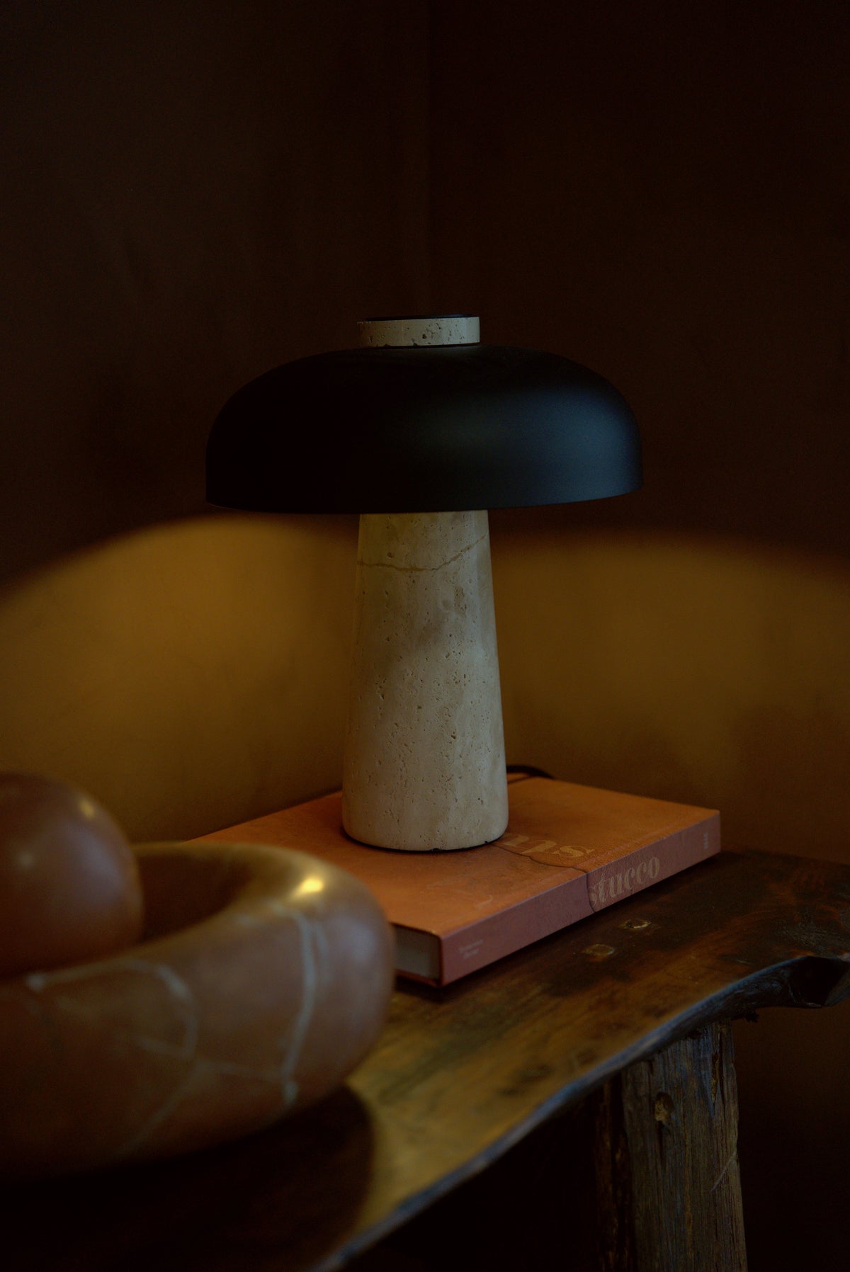 The Corvus lamp in the 34 cm size, unlit on a console in evening light.